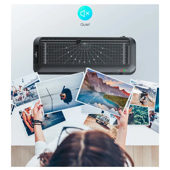 Laminador negro junto a varias fotografías impresas sobre una mesa
