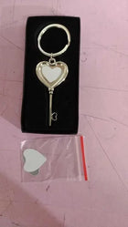 Llavero con forma de llave antigua dentro de caja negra con lámina blanca