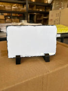 Roca rectangular blanca montada en soportes negros sobre una caja