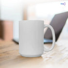 Tazón blanco sublimable de 15 oz sobre un escritorio junto a un computador