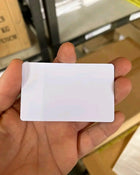 Tarjeta de PVC blanca sublimable sostenida en una mano